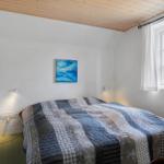 Schlafzimmer mit Bett, Fenster und Wandbild.
