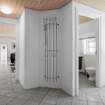 Flur mit Garderobe, Blick in Küche und Badezimmer mit Toilette.