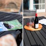 Auf der Terrasse steht ein Tisch mit Wein, Gläsern und Broschüren.