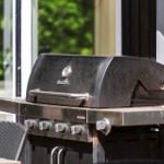 Gasherd mit vier Brennern und Deckel auf einer Terrasse.