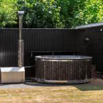 Hochwertiger Whirlpool mit Holzrahmen und Metallverkleidung im Gartenbereich.