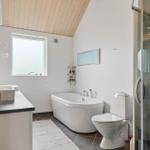 Badezimmer mit freistehender Badewanne, Dusche und Waschbecken mit Spiegel.