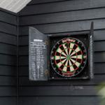 Dartboard mit Tafel an schwarzer Holzwand montiert.