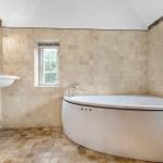 Bad mit Badewanne, Waschbecken und Fenstern