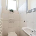 Badezimmer mit Toilette, Waschbecken und Spiegel mit Muschel- und Sternenmotiven.