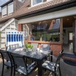 Terrasse mit Tisch, Stühlen und Liegestuhl. Durchgang ins Haus. Blick auf Wohnbereich.