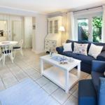 Living and dining area with sofa, table, and garden view