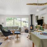 Wohn- und Essbereich mit Kamin, Sofa, Stuhl und Spielplatte.