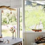 Essbereich mit Tisch, Spiel und Lichtern. Fenster mit Segelschiffmodell und Kamin.