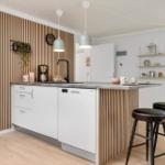 Küche mit Holzwand, Arbeitsplatz und Barhocker