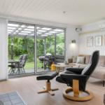 Wohnzimmer mit Sofa, Sessel und Blick auf die Terrasse