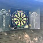 Dartscheibe mit Tafeln an Wand montiert, Darts in Halterung