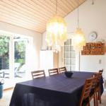 Esszimmer mit Holztisch, Stühlen und Schalentischlampen. Durchgang zur Schlafzimmer.