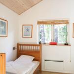 Ein Schlafzimmer mit Holzbett, Fenster und Wandbildern.