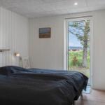 Schlafzimmer mit Bett, Tür zum Garten und Wandbild.