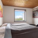Schlafzimmer mit Bett, Fenster und Wandbildern
