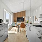 Küche mit Essbereich und Wohnzimmer im Hintergrund.