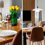 Holztisch mit Stühlen, Blumen und Flasche. Hintergrund mit Wandverkleidung und Lampe.