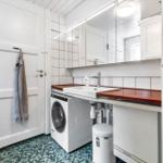 Badezimmer mit Waschmaschine, Spiegel und Holzoberfläche