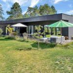 Modern villa with garden, terrace, and green umbrellas.