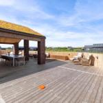 Terrasse mit Holzdecke, Sitzgruppe und Tisch unter Dach