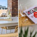 Tisch mit Wein, Gläsern und Buch auf Terrasse
