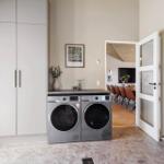 Wohnraum mit Waschmaschine und Trockner, Tür führt in Esszimmer.