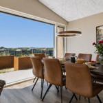 Esszimmer mit Sicht auf den Strand und Terrasse mit Pflanzenkästen.