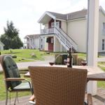 Terrasse mit Tisch und Stühlen. Im Hintergrund stehen mehrstöckige Häuser.