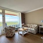 Living room with balcony view. Sofa, armchair, and table.