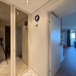 Hallway with view into kitchen and living room with seating and window.