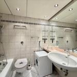 Bathroom with shower, toilet, washing machine, and sink.