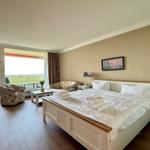 Bedroom with double bed, seating, and balcony view.
