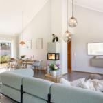 Wohnzimmer mit Sofa, Kamin und Esstisch. Durchgang zur Terrasse.