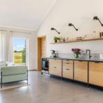 Küche mit Holzschränken und Blick auf Felder
