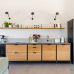 Moderne Küche mit Holzschränken, Edelstahlkühlschrank und Küchenzeile.