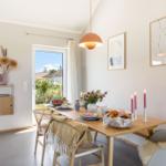 Esszimmer mit Holztisch, Stühlen und Blick auf den Garten.