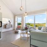 Wohnzimmer mit Kamin, Sofa und Blick auf Felder