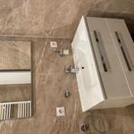 Badezimmer mit Waschbecken, Spiegel und Heizkörper