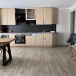 Kitchen with laminate cabinets, stainless steel appliances, and dining table with chairs.