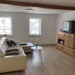 Living room with sofa, TV, and wooden furniture.
