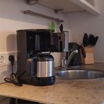 Küchenzeile mit Kaffeemaschine, Spüle und Messerblock.