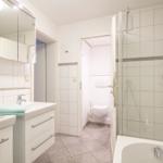 Badezimmer mit Dusche, Badewanne, Waschbecken und Toilette