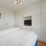 Bedroom with double bed, white wardrobes, and built-in TV.