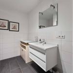 Bathroom with shower, sink, and mirror on the wall.