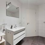 Bathroom with sink, mirror, and shower.
