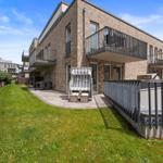 Modern house with balcony, garden, and lounge chair. Ideal for vacation.