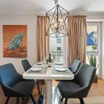 Dining room with table, chairs, and view of balcony