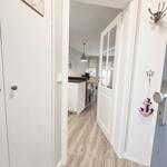 Hausgang mit Holzboden und Tür zum Essbereich. An der Wand hängt ein Anker.