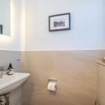 Badezimmer mit Waschbecken, Spiegel und Wandbild.